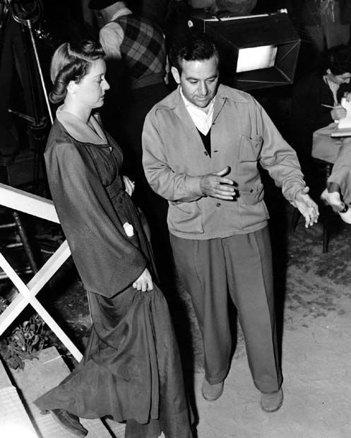Director William Wyler shows Bette Davis how to go down stairs while shooting someone. Image: Pinterest